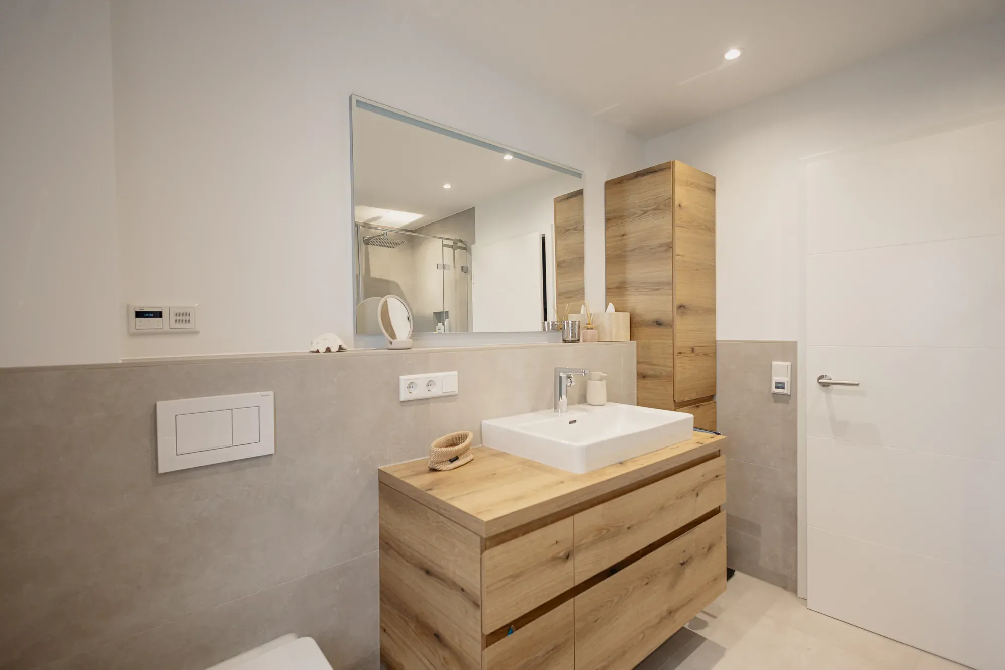 Saniertes Bad mit Eichen-Waschtisch, Hochschrank und Wand in Betonoptik