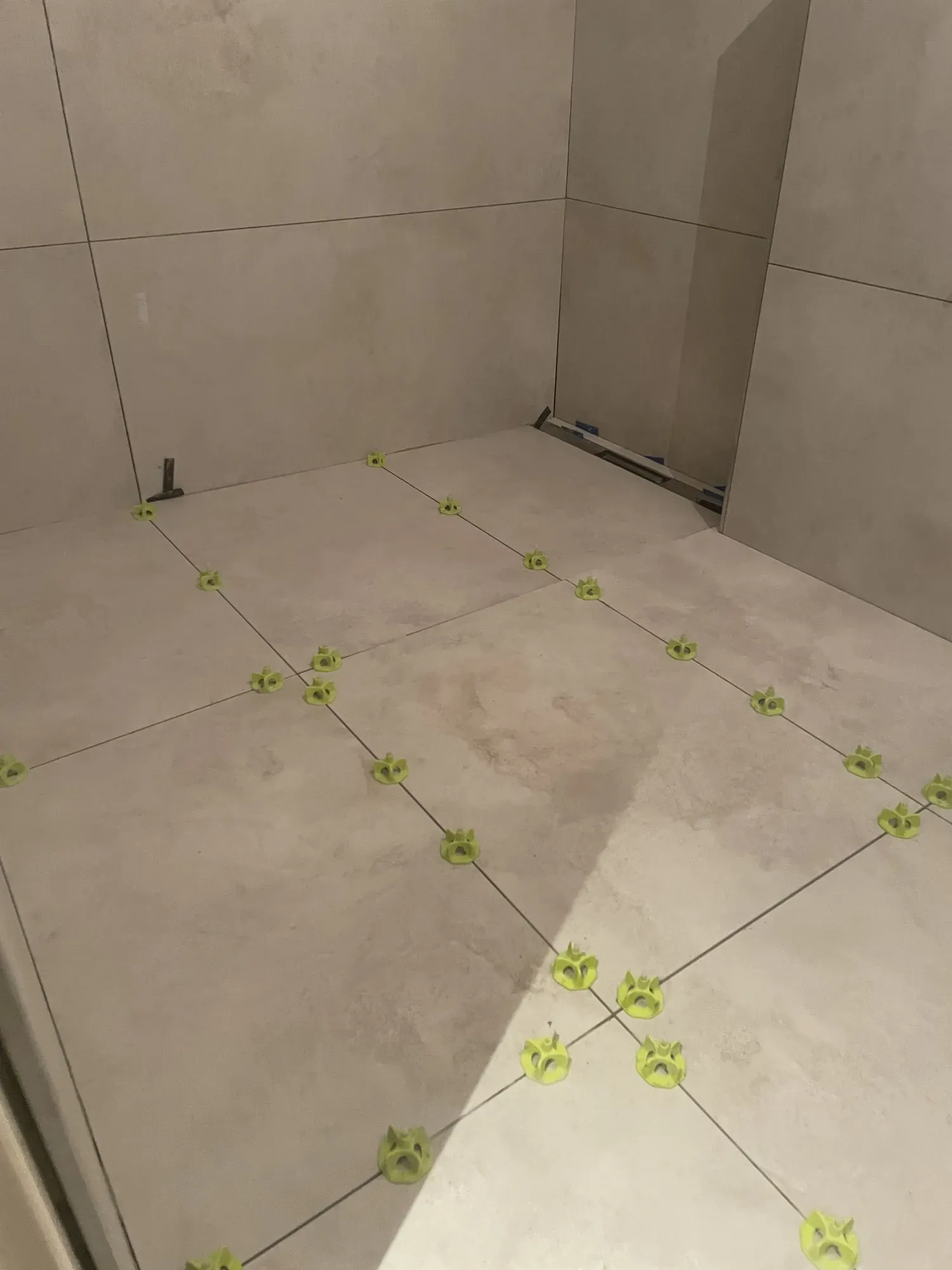 Bodenfliesen mit Nivellierkeilen in einer bodengleichen Dusche